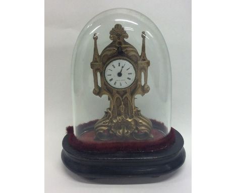 A small French brass mounted mantle clock contained within a dome. Approx. 17 cms high. Est. £30 - £40.