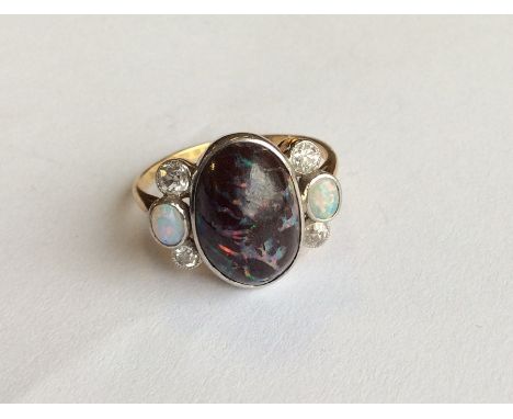 An unusual Edwardian matrix opal and diamond seven stone ring in 18 carat two colour gold mount. Approx. 5 grams. Est. £500 -