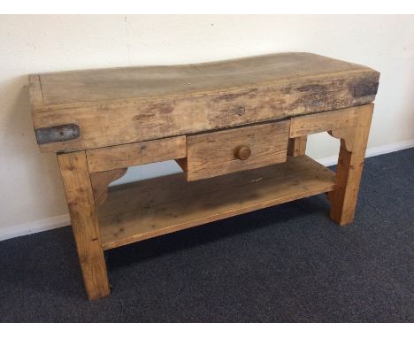 A massive butcher's block of typical form mounted upon a single drawer stand with shelf to base. Est. £200 - £300.