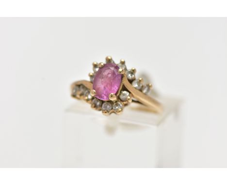 A 9CT GOLD RUBY AND DIAMOND RING, centring on an oval cut ruby, in a four claw setting, with single cut diamond cross over sh