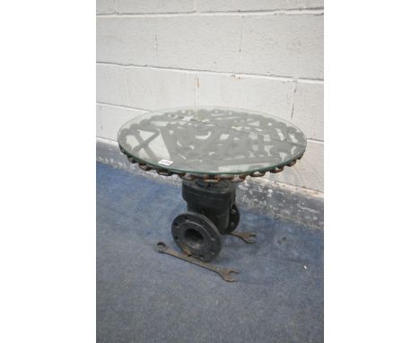 A BESPOKE OCCASIONAL TABLE, made up of mechanic tools and engine parts, with a glass top, diameter 60cm x height 47cm