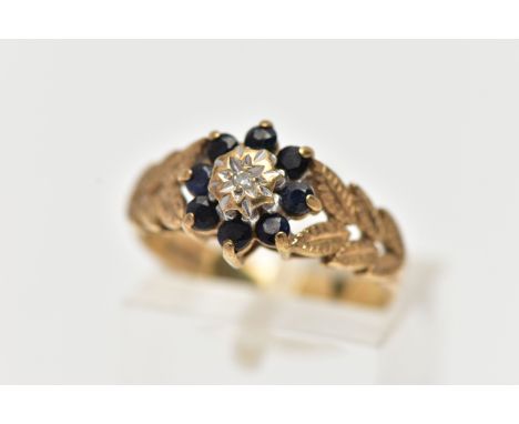 A 9CT GOLD DIAMOND AND SAPPHIRE CLUSTER RING, the illusion set single cut diamond, within a circular cut sapphire surround, t