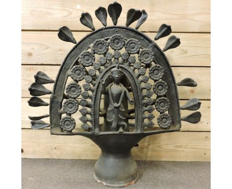 A black painted terracotta model of an Indian deity, surmounted by cobras, 73cm tall