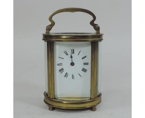 A French brass cased carriage clock, with a white enamel dial, 15cm tall overall