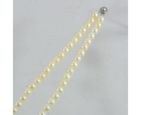 A pearl single strand necklace, on a metal clasp