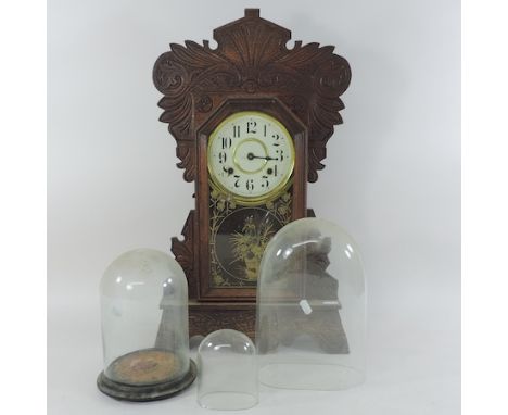 An early 20th century carved mantel clock, 58cm tall, together with a glass dome and two others