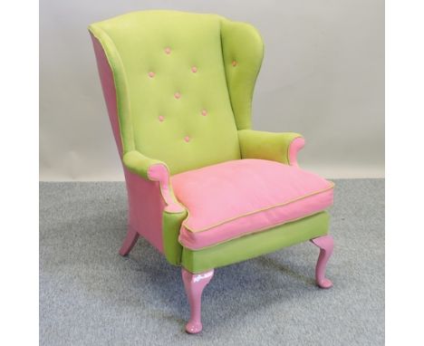 A green and pink upholstered button back wing armchair, bearing a label for Treacle Furniture Company