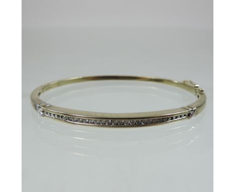 An unmarked diamond set bangle, of hinged shape set with a single row of diamonds, approximately 0.25 carat gross, 6cm diamet