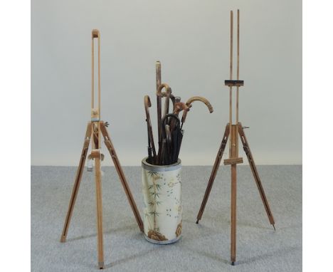 A collection of walking sticks, together with a pottery stick stand, 50cm tall, and two artist's easels