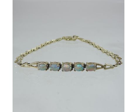 An early 20th century 14 carat gold opal five stone bracelet, with a hinged clasp  