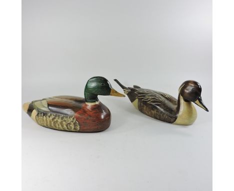 A Ron Anderson carved wooden model of a duck, together with another, signed, largest 50cm long