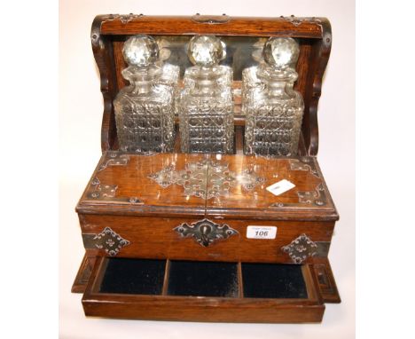 Oak-cased Tantalus with three cut-glass decanters  CONDITION REPORT; Good overall condition, one decanter has a chip to the r