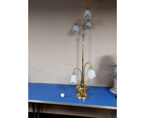 A contemporary brass standard lamp with opaque glass shades, together with a similar table lamp   