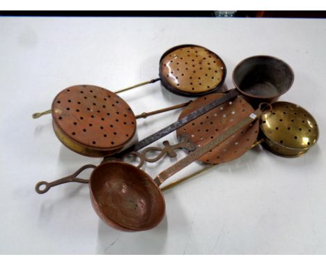 A basket containing four antique chestnut roasters together with an antique copper ladle and an antique copper cast iron hand
