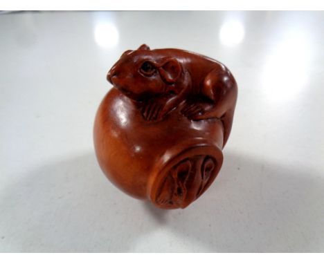 A carved Chinese hardwood netsuke, two rats on a pot  