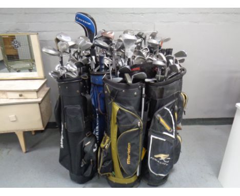 Twelve assorted golf bags containing assorted irons, drivers and putters to include Tailor Made, Dunlop, Howson etc  