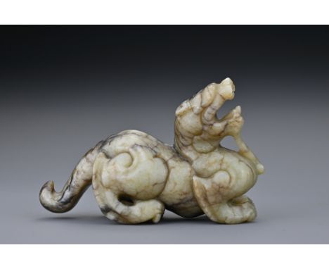 A Chinese Ming dynasty or later mottled jade carving of a mythical beast. The jade in greyish-green colour with areas of dark