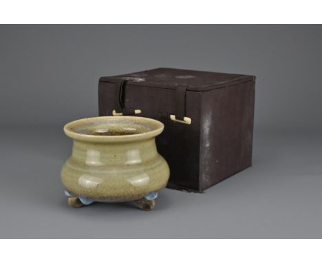 A Chinese Yuan/Ming Dynasty Junyao Tripod censer. The squat globular form body on three compressed feet covered in a green cr