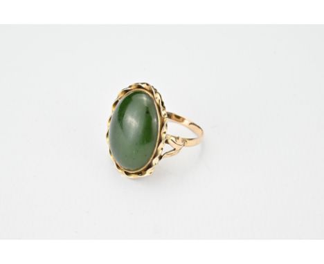 A 14K yellow gold ring with 'rope twist' design inserted with a green stone cabochon, possibly jade. Marked twice with 14K to