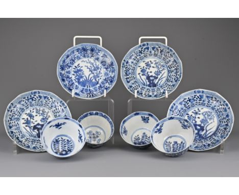 A group of Chinese 19th Century blue and white porcelain cups and saucers. Four matching saucers with three cups, one separat