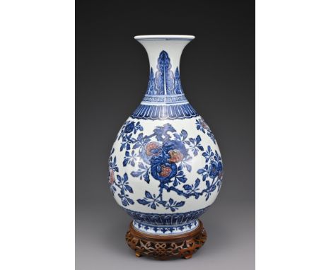 A Chinese underglaze blue and copper red porcelain pear-shaped vase, Yuhuchunping. The vase decorated with 'sanduo' the three