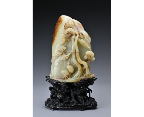 A large Chinese celadon and russet jade boulder. Carved in high relief with two cranes and pine trees, with inscribed inscrip