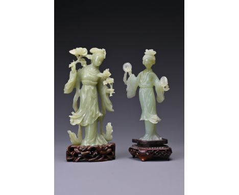 Two Chinese jade / serpentine carvings of Guanyin on wooden stands. Height 20 cm (2) 