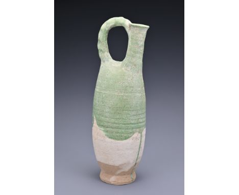 A Chinese Liao dynasty (907-1125) green-glazed stoneware flask. The tall cylindrical body leading to a narrow cylindrical spo