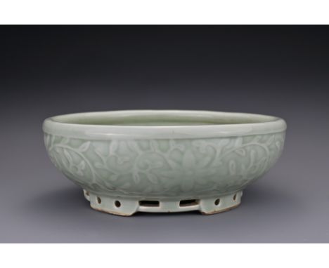 A Chinese 18/19th century carved celadon-glazed porcelain censer. The exterior carved with floral scrolls covered in a pale c