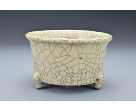 A Chinese Geyao-type ceramic tripod censer. The cylindrical censer covered in crackle glaze with five spur marks to the inter