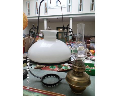 Brass oil lamp and flue with hanging metal ceiling light with clouded glass shade
