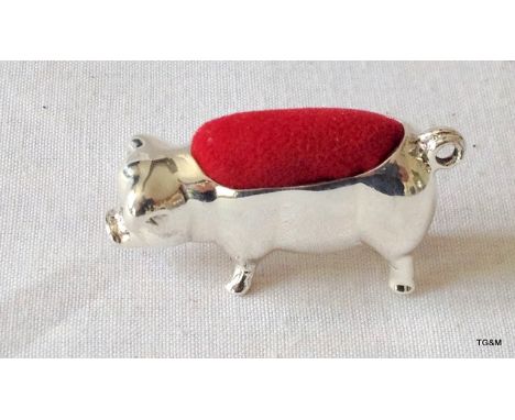 A silver pig pin cushion