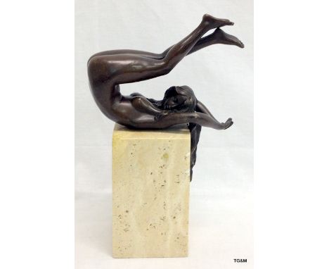 A bronze figure of a lady stretching