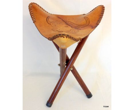 A tripod fold up cow hide stool