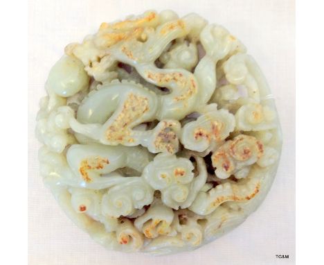 A carved Chinese Celadon jade ornament in a dragon scroll pattern diameter 8.9cm