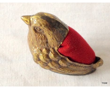 A brass pin cushion in the form of a bird