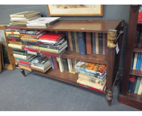 A George III mahogany dwarf bookcase with shaped top, an adjustable shelf, flanked by fluted tapering pilasters with gilt cap