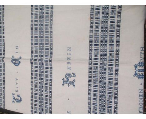 An early 20th century blue embroidered bed spread with hand applied German cross stitch lettering, a beige and cream embroide