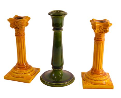 A pair of Burmantoft pottery Corinthian column candlesticks, with a yellow glaze, impressed and monogram to underside, 20cm h