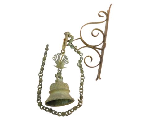 A bronze effect metal doorbell, with peacock shaped mount, and wrought iron bracket, the bracket 45cm high.