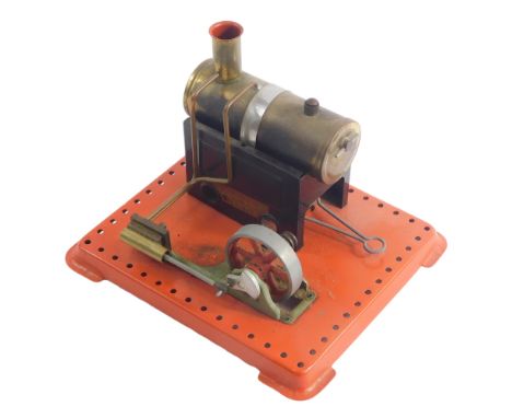 A Mamod static engine, with brass effect boiler, etc., on a red painted base, 20cm wide. 