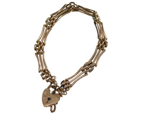 A 9ct rose gold three bar gate bracelet, on a heart shaped padlock clasp, with safety chain as fitted, 14.9g. 