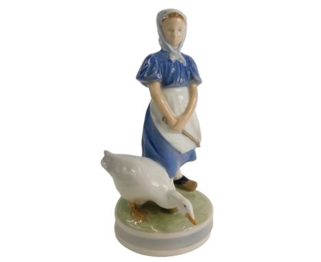 A Royal Copenhagen porcelain figure of a young girl with a goose, on a circular base, printed marks to underside, numbered 52