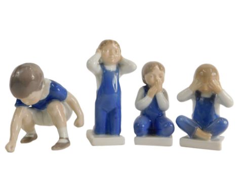 A collection of four Royal Copenhagen and similar porcelain figures of seated children, each wearing blue dungarees.