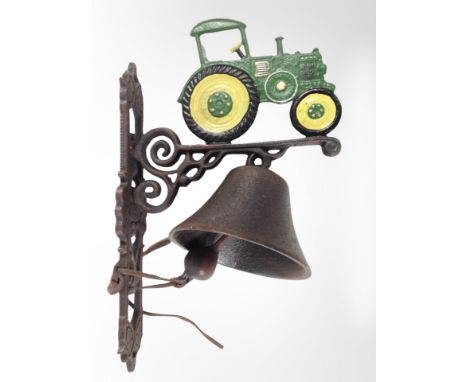 A cast-iron tractor wall-mounted bell on bracket, length from wall 23cm.