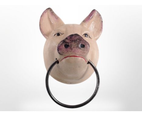A cast-iron pig head with metal ring, length 13cm from the wall.