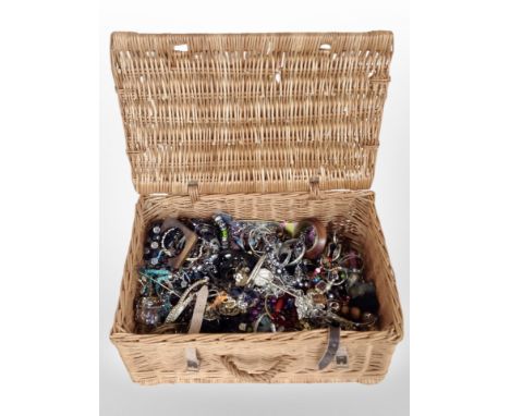 A wicker hamper containing a large quantity of costume bead necklaces, bangles, dressing table mirror, etc.