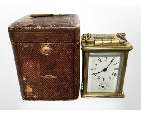 A miniature brass carriage clock, height 11cm including handle, in original leather travel case.