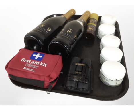 Two bottles of Prosecco, a first aid kit, small pair of binoculars, a bottle of argan oil heat defence spray, and a five jars