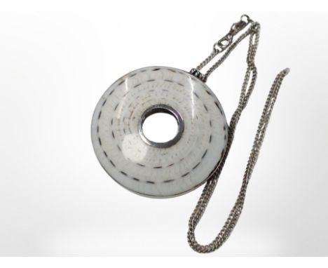 A silver polished shell pendant on chain, pendant 4.5cm diameter.